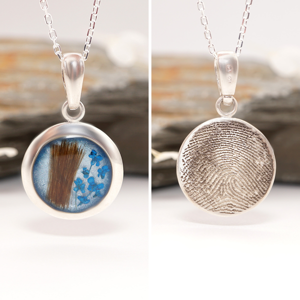 Two silver pendants with a fingerprint and a lock of hair.